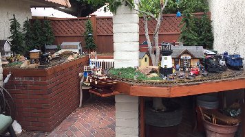 Redwood deck garden railroad German Pola buildings and German LGB trains. The deck makes it easier to work on them. There are planter boxes in the deck for live plants.